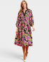 Woman wearing a colorful floral dress on a white background