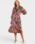 Woman wearing a colorful floral dress on a white background