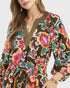 Woman wearing a colorful floral patterned dress on a white background