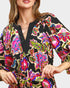Colorful patterned dress worn by a model on a plain background