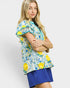 Woman wearing a colorful blouse with lemon pattern on a white background