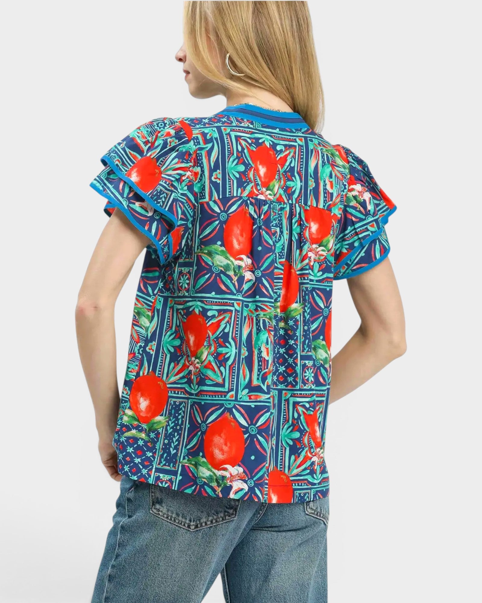 Person wearing a colorful floral shirt with red flowers on a white background