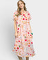 Woman wearing a pink dress with colorful fruit pattern on a white background