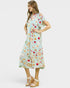 Woman wearing a colorful dress with a pattern on a white background