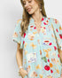 Woman wearing a colorful patterned dress with a plain background
