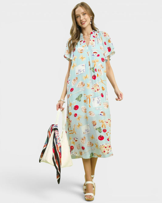 Woman wearing a colorful dress with a pattern of animals and plants on a white background