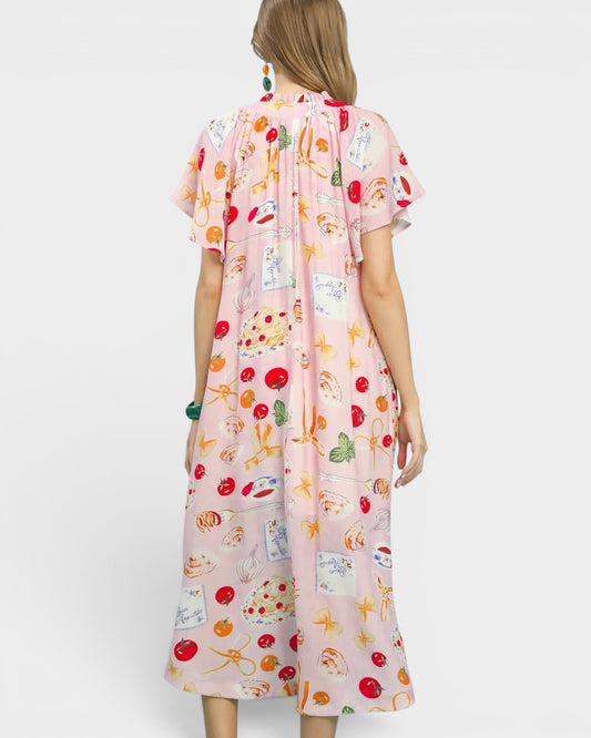 Woman wearing a pink dress with colorful prints on a white background