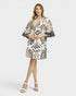 Woman wearing a patterned dress on a white background