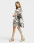 Woman wearing a patterned dress on a white background