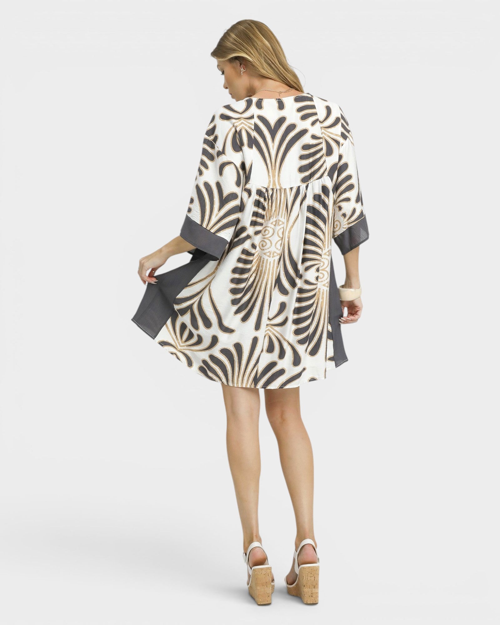 Woman wearing a patterned dress on a white background