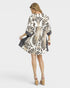 Woman wearing a patterned dress on a white background