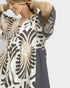Woman wearing a patterned dress with a plain background