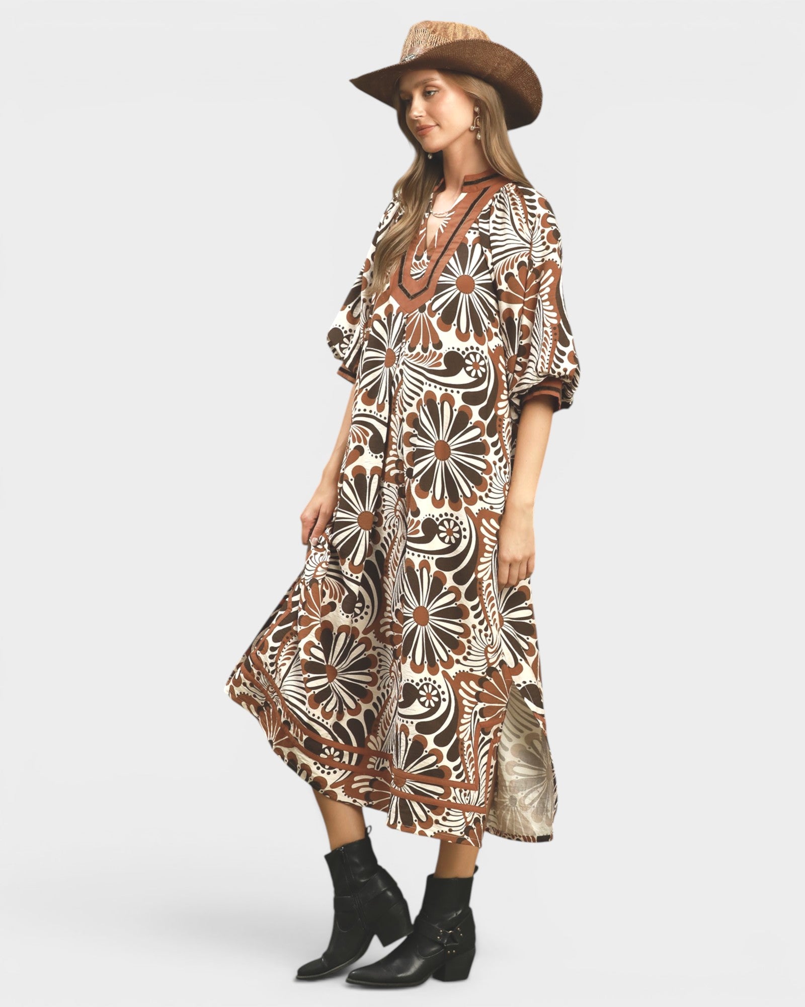Woman wearing a patterned dress and hat on a white background