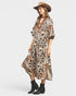 Woman wearing a patterned dress and hat on a white background