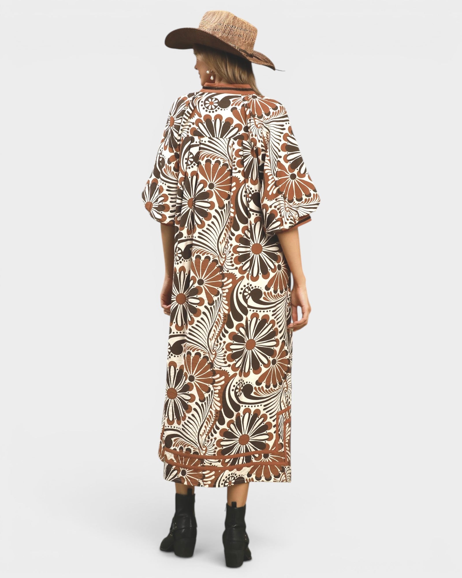 Person wearing a patterned dress and hat on a white background