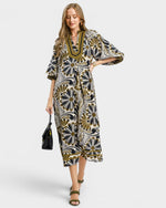 Woman wearing a patterned dress on a white background