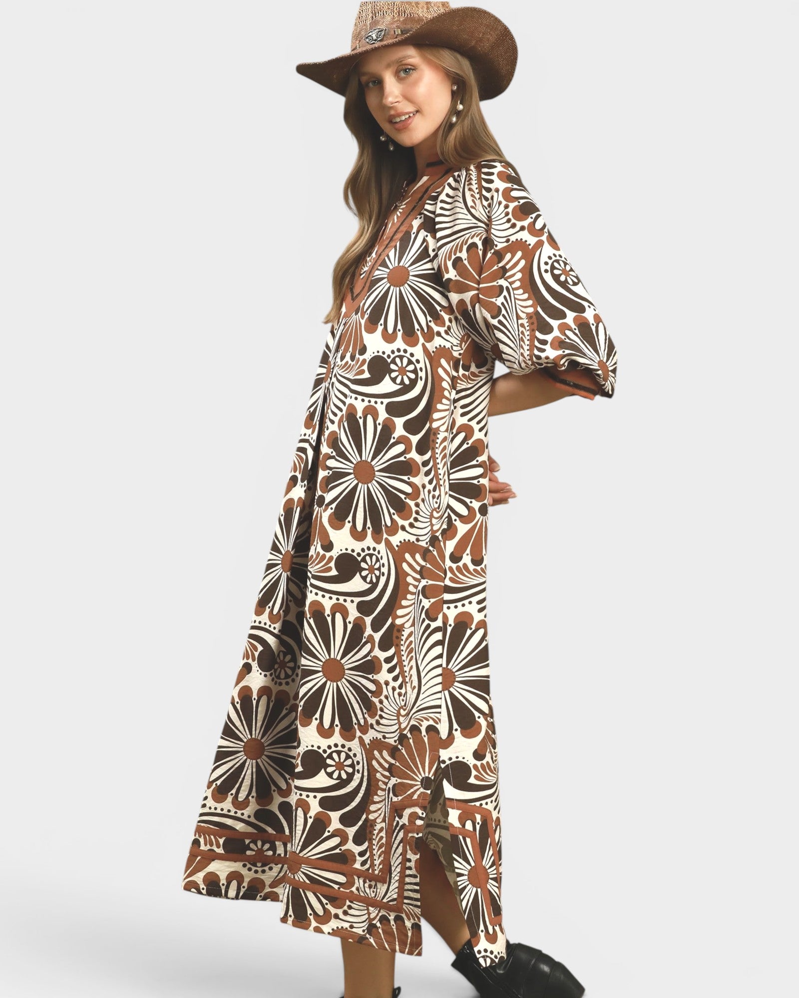Woman wearing a patterned dress and hat on a white background