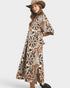 Woman wearing a patterned dress and hat on a white background