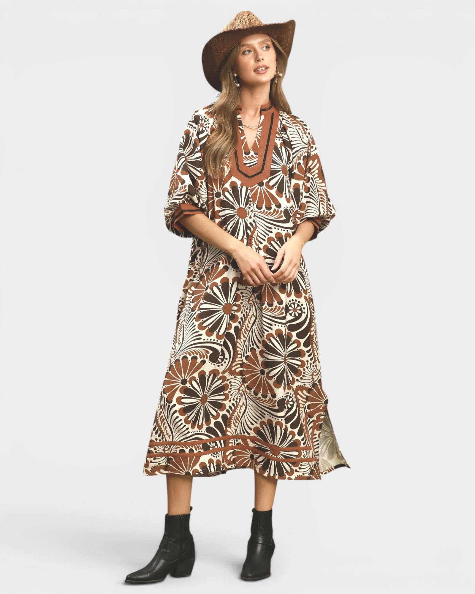 Woman wearing a patterned dress with a hat on a white background