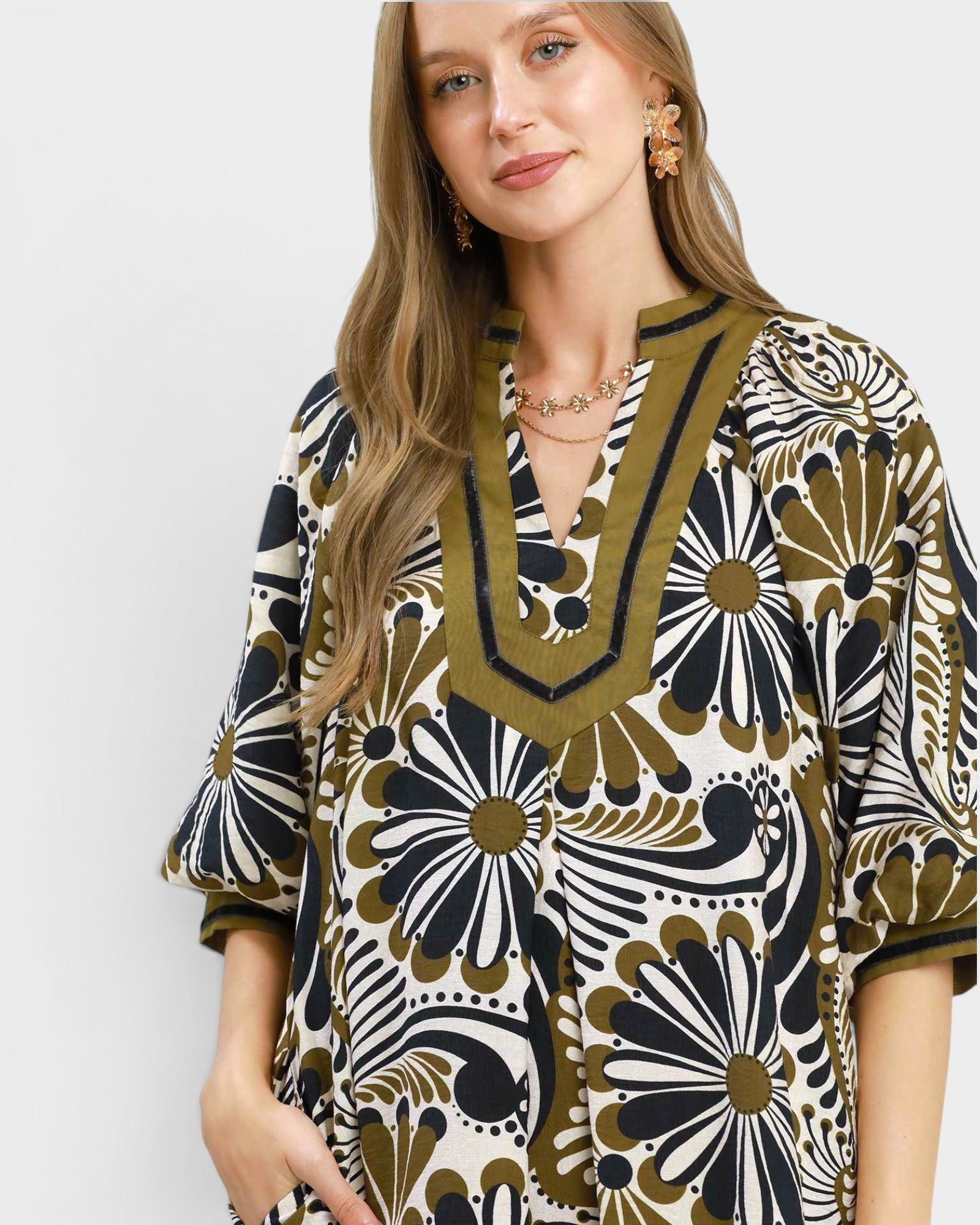 Woman wearing a patterned dress with a neutral background