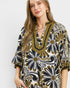 Woman wearing a patterned dress with a neutral background