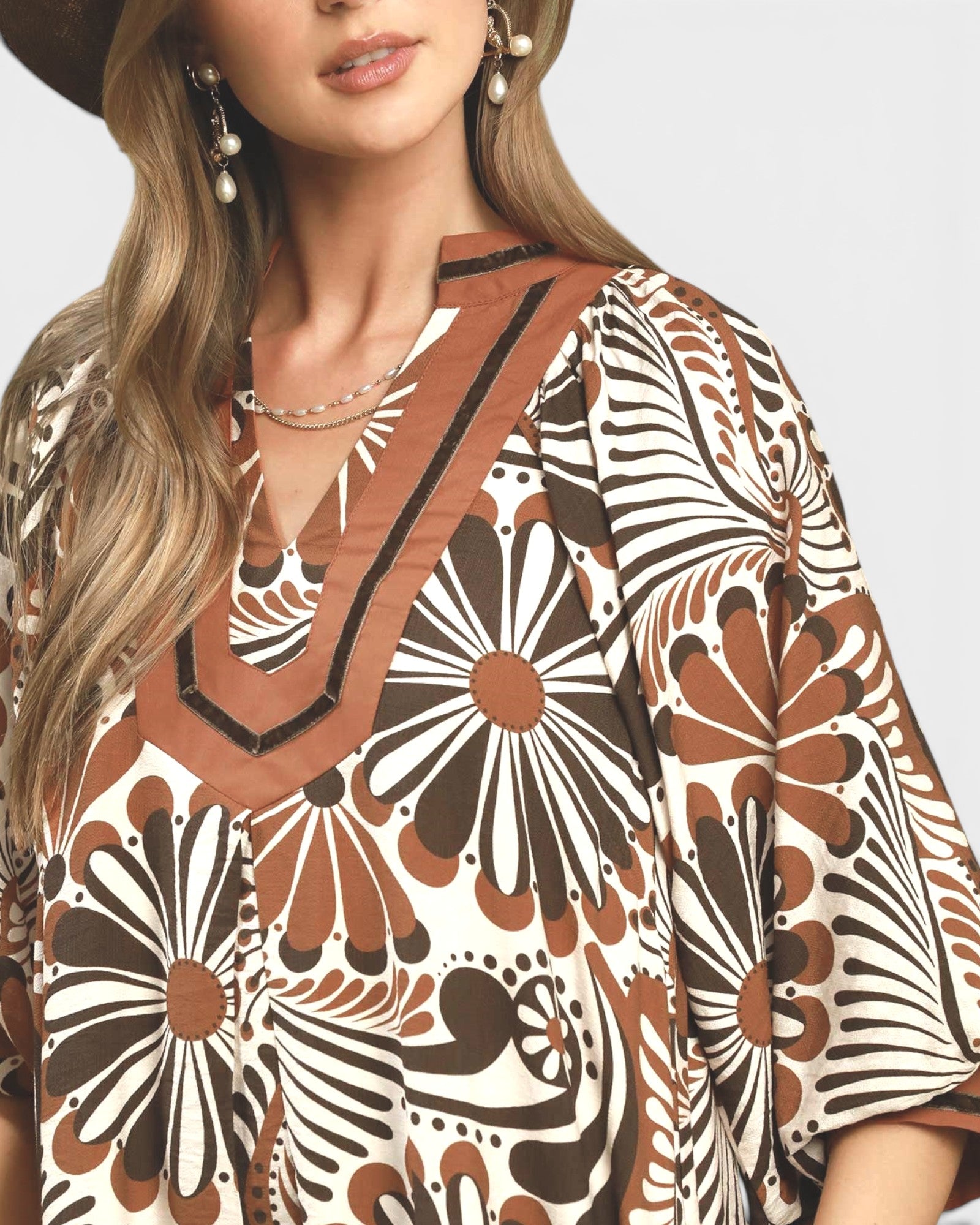 Woman wearing a patterned dress with a neutral background