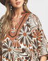 Woman wearing a patterned dress with a neutral background