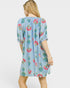 Woman wearing a light blue dress with floral patterns on a white background