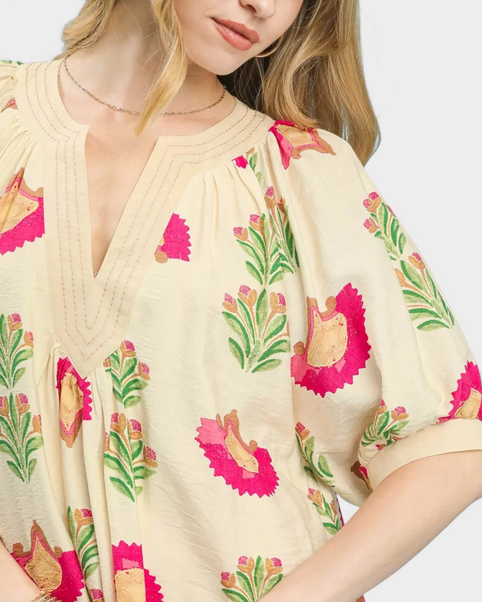 Beige top with floral patterns on a plain background