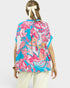 Woman wearing a colorful floral patterned top on a white background