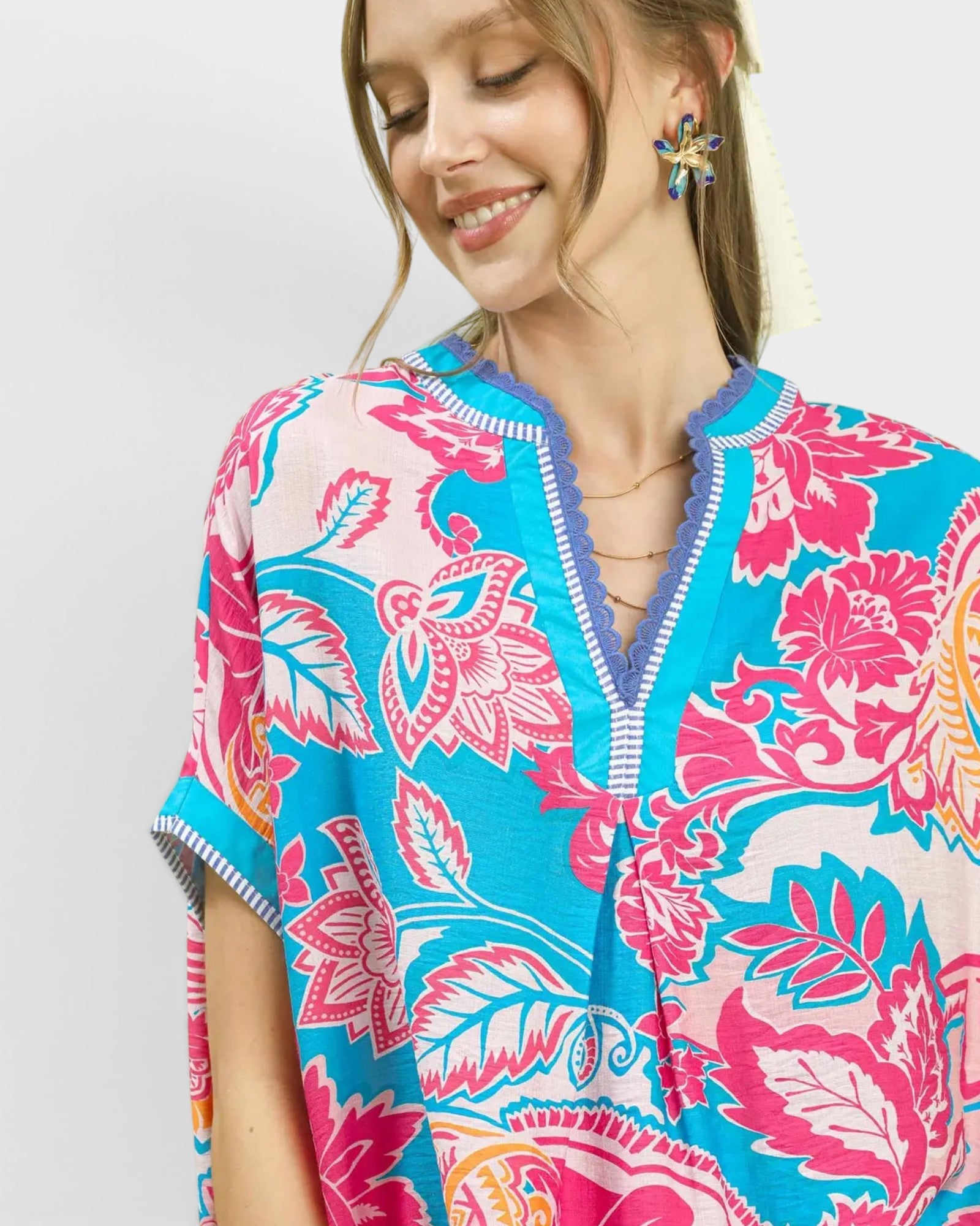 Woman wearing a colorful floral dress with a plain background