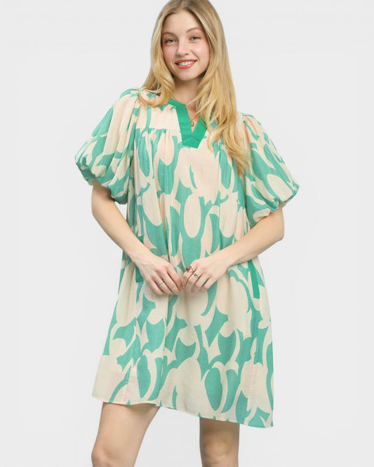 Woman wearing a green and beige patterned dress on a white background