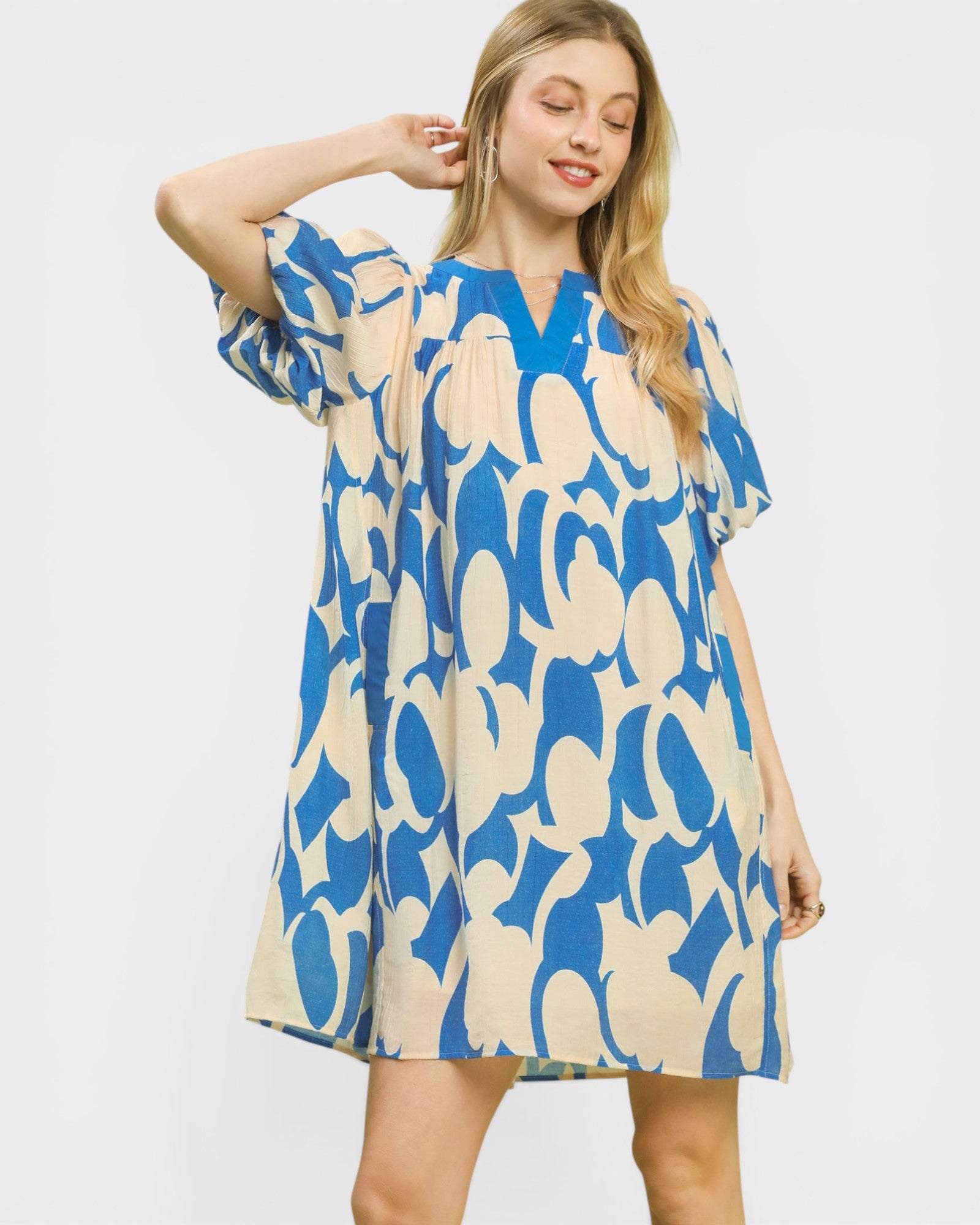 Woman wearing a blue and beige patterned dress on a white background