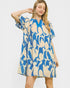 Woman wearing a blue and beige patterned dress on a white background