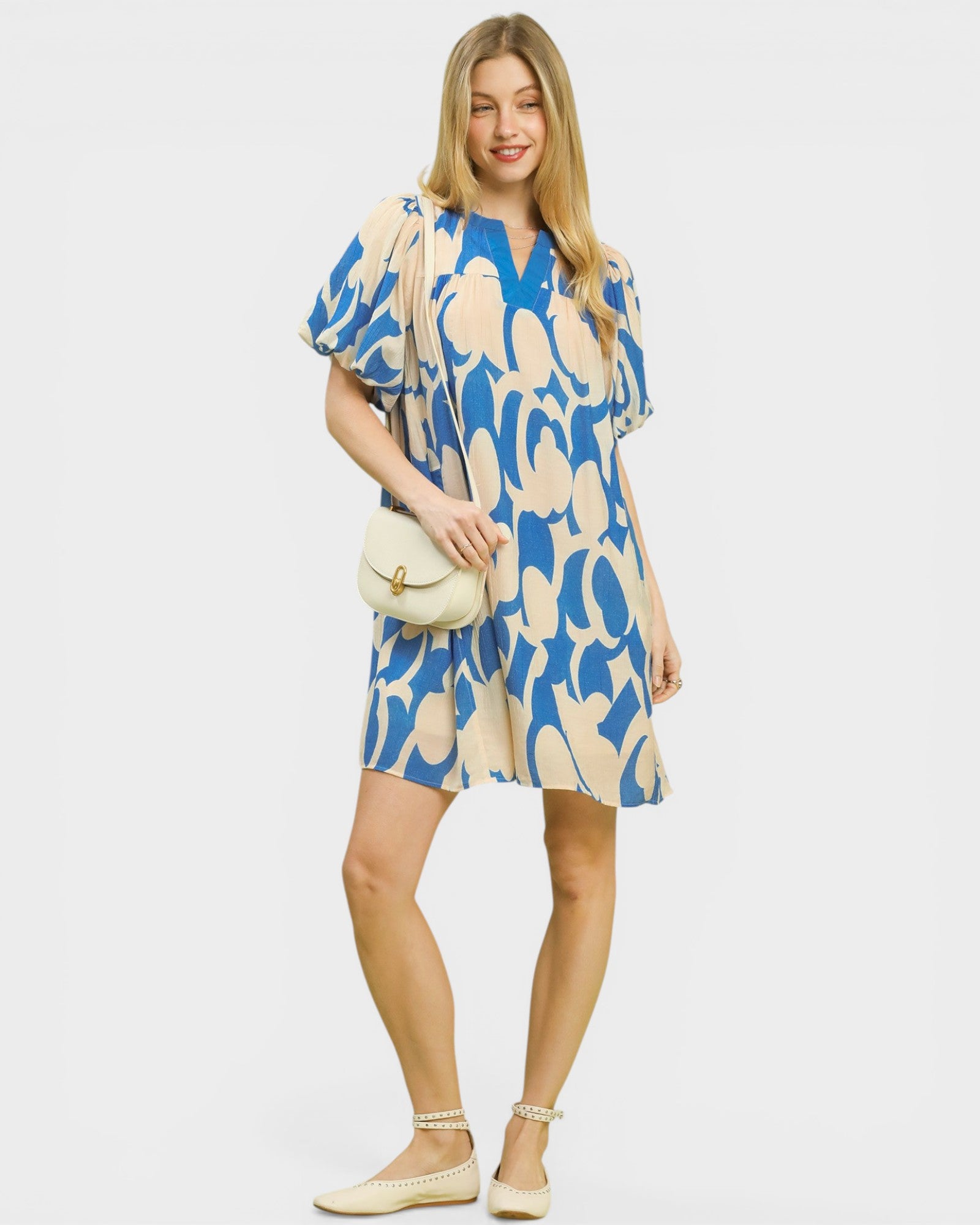 Woman wearing a blue and beige patterned dress on a white background