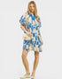 Woman wearing a blue and beige patterned dress on a white background
