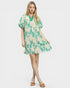 Woman wearing a green and beige patterned dress on a white background