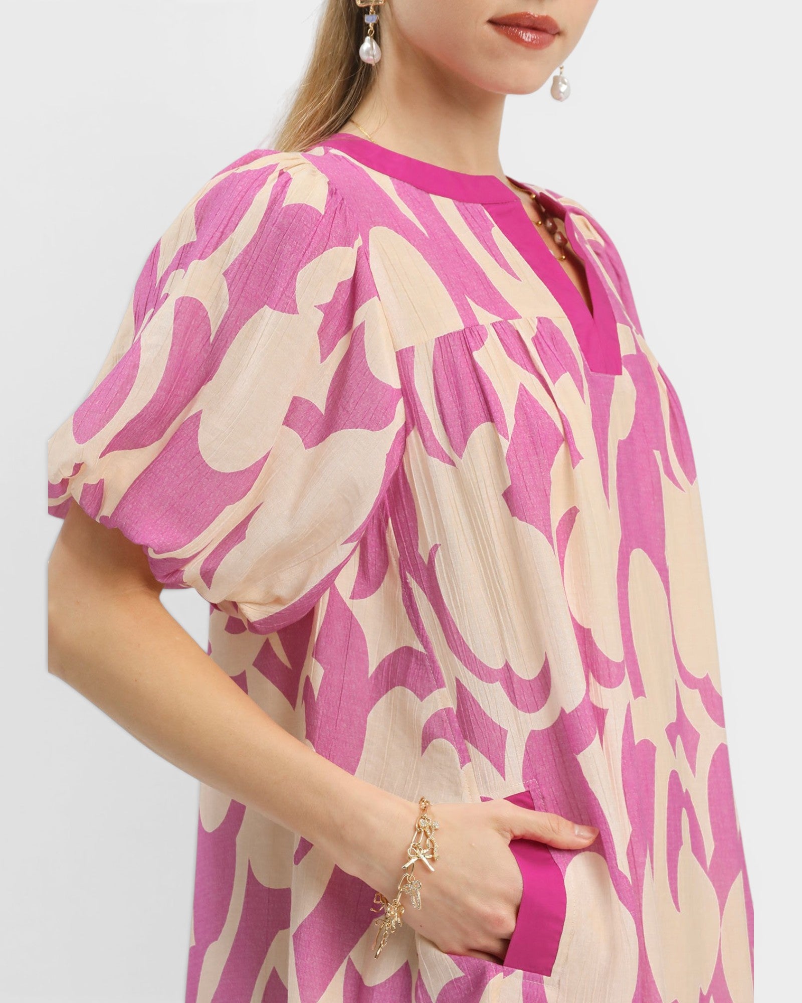 Woman wearing a pink and beige patterned dress on a white background