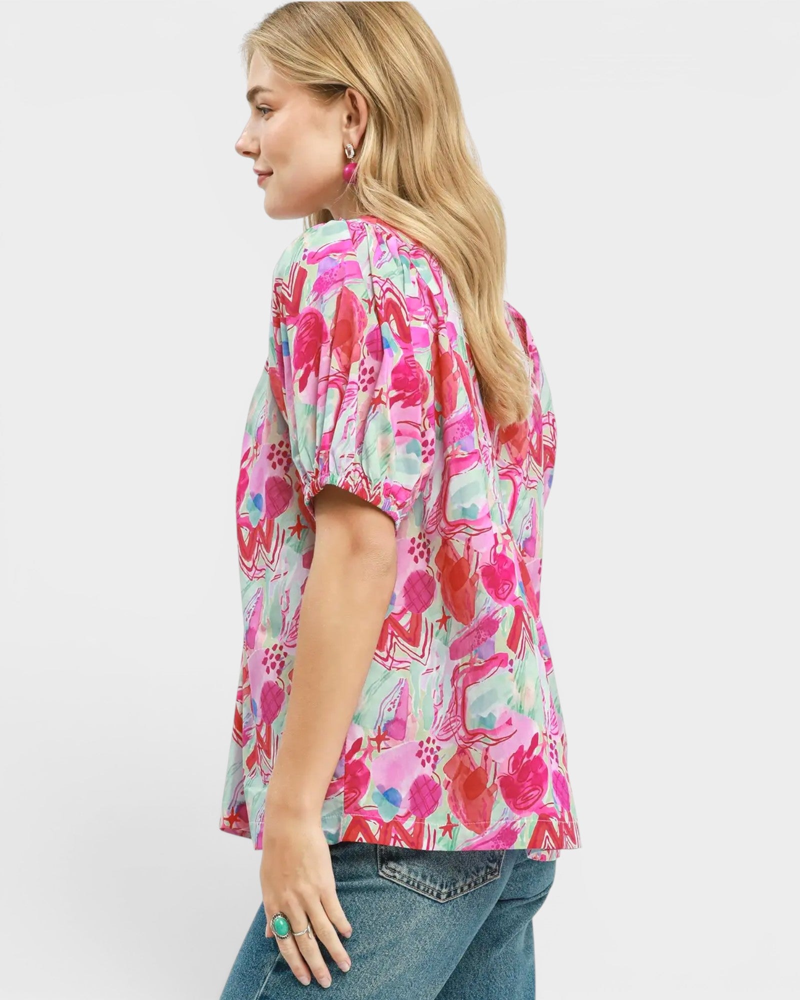 Woman wearing a colorful patterned shirt on a white background