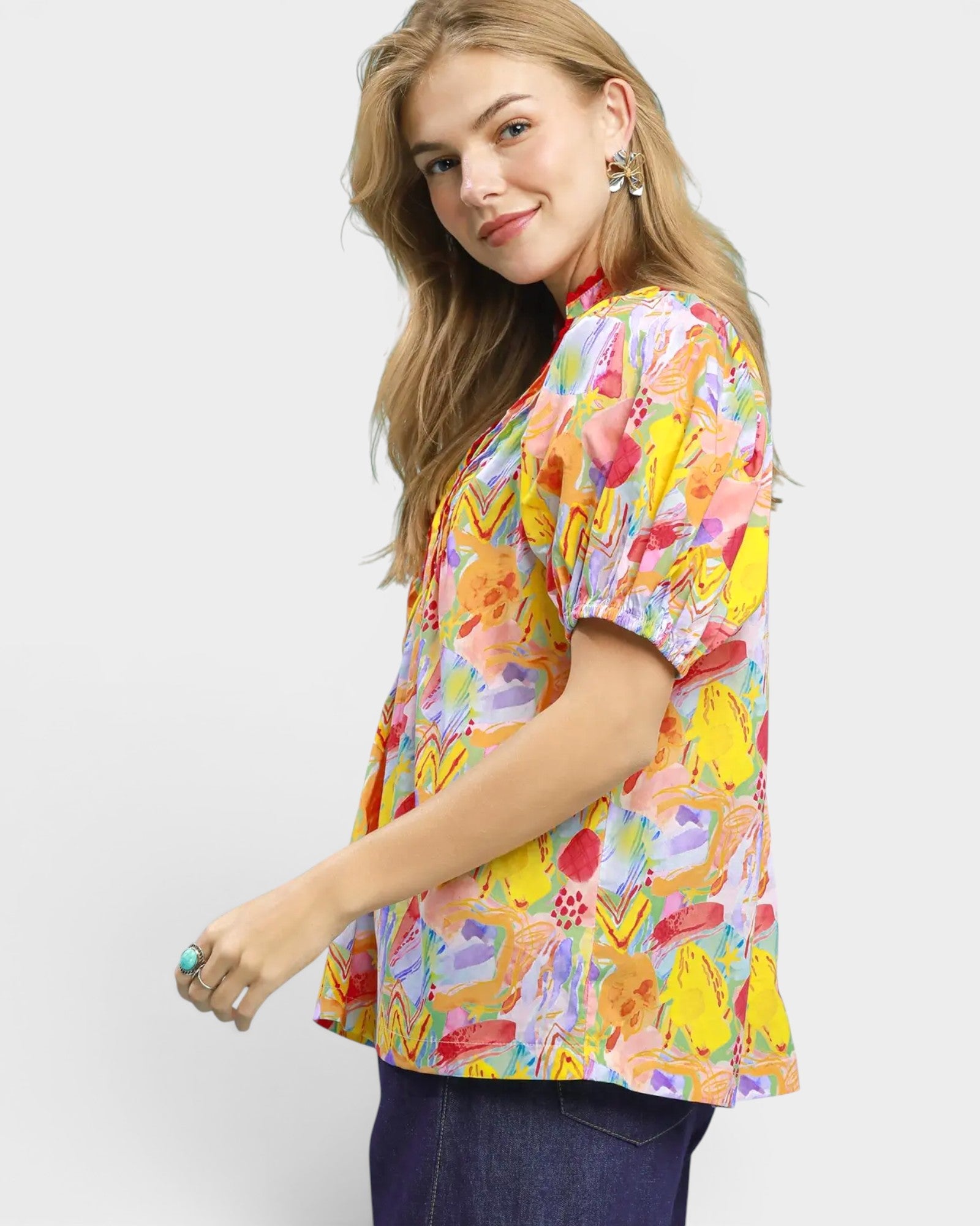 Woman wearing a colorful floral blouse against a white background