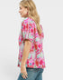 Woman wearing a colorful patterned shirt on a white background