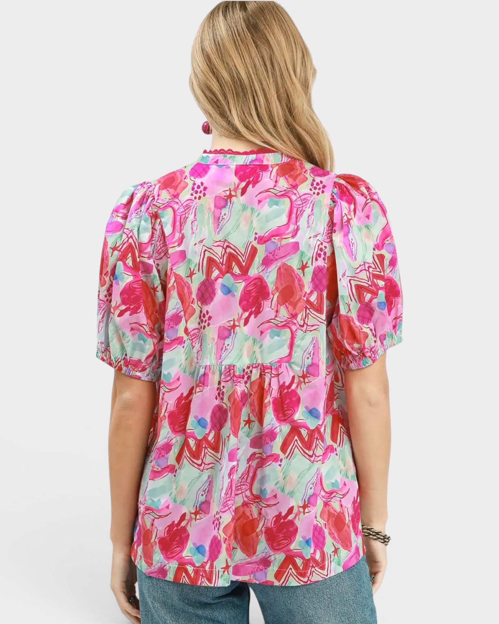 Woman wearing a colorful floral blouse on a white background