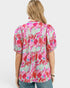 Woman wearing a colorful floral blouse on a white background