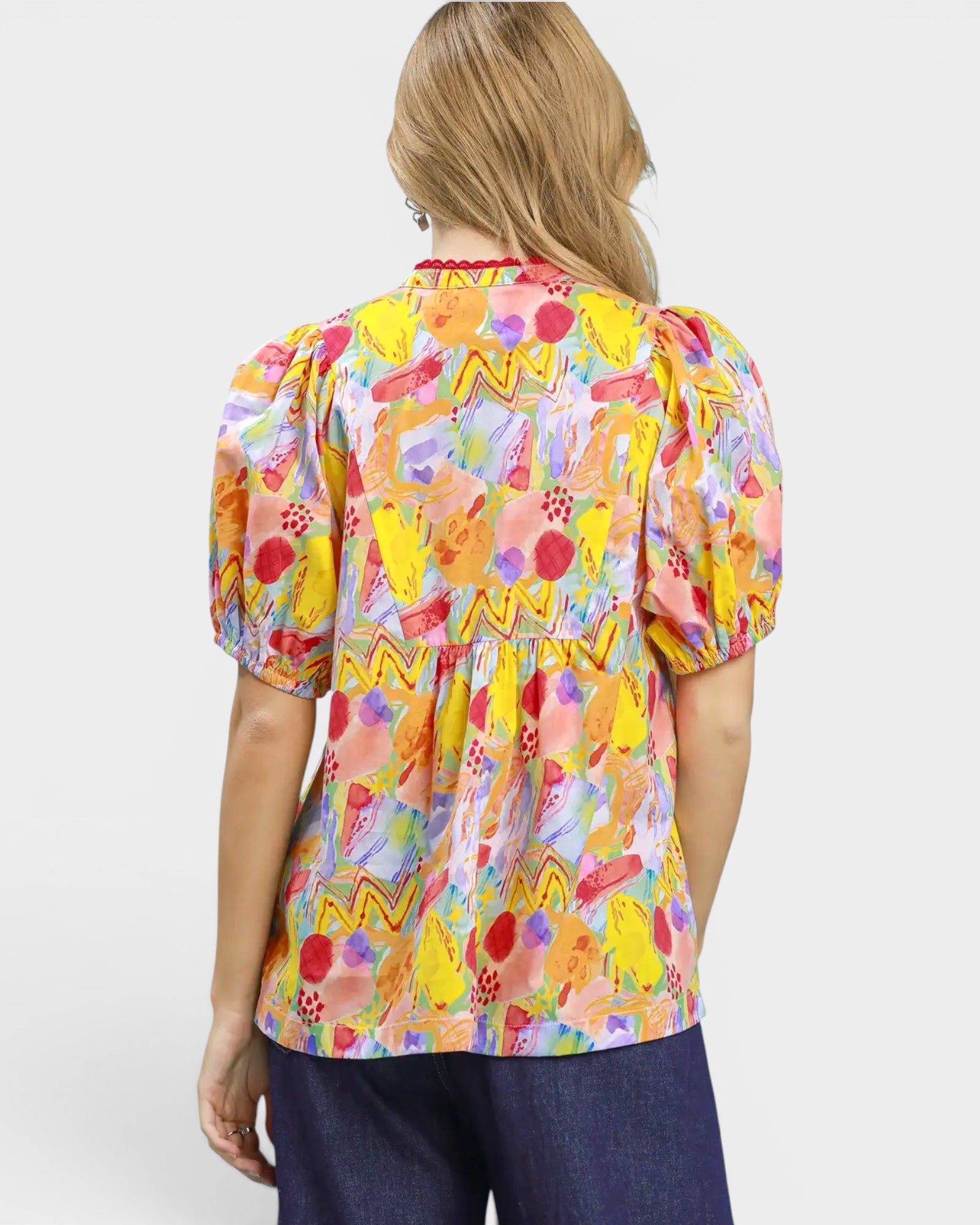 Woman wearing a colorful patterned blouse on a white background