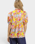 Woman wearing a colorful patterned blouse on a white background