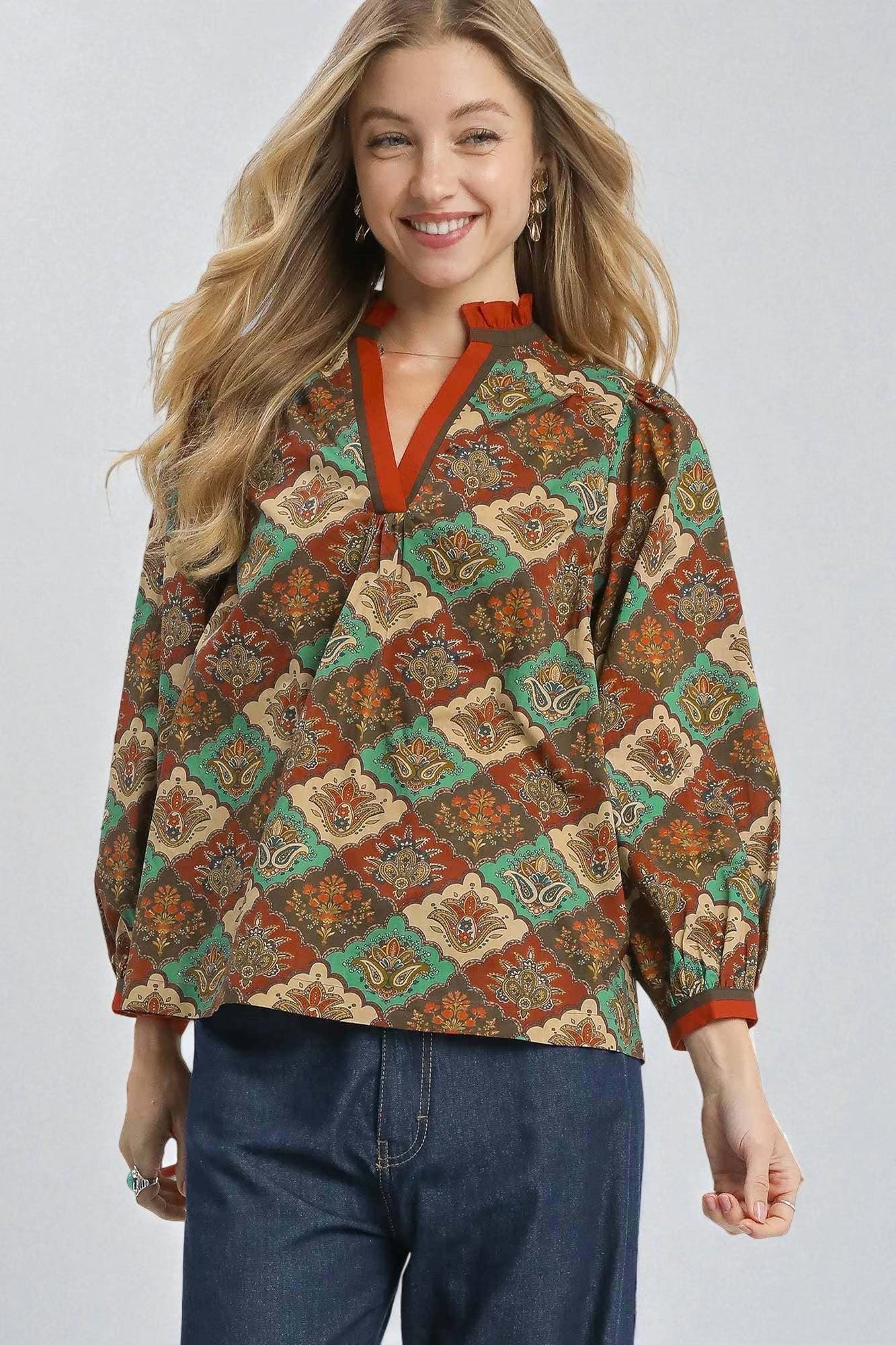 Woman wearing a patterned shirt with a plain background