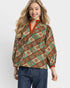 Person wearing a patterned blouse with a white background