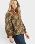Woman wearing a patterned blouse on a white background
