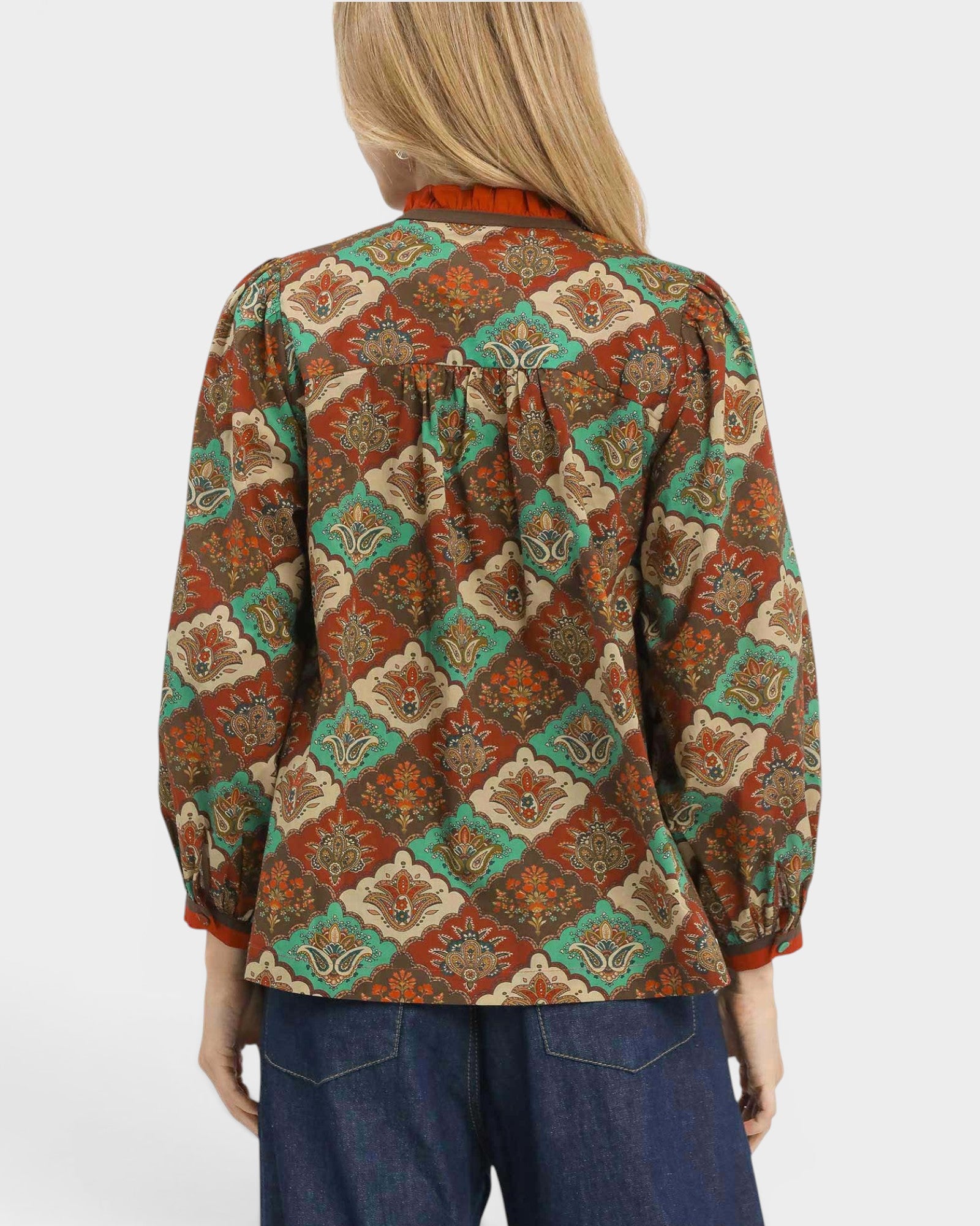 Person wearing a patterned blouse with a white background