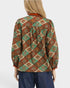 Person wearing a patterned blouse with a white background